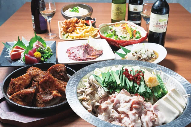 忘年会コースの料理。刺身、マグロ頬肉のステーキ、もつ鍋、ローストビーフのカルパッチョ