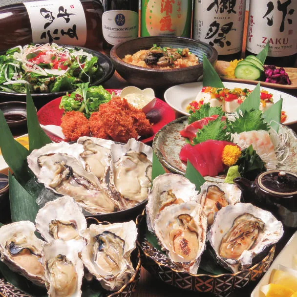 ちゅるりの忘年会コース。生牡蠣、焼き牡蠣、刺身盛り合わせ、カキフライが並ぶテーブル